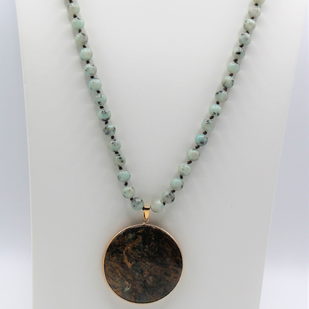 Long knotted green necklace with round pendant